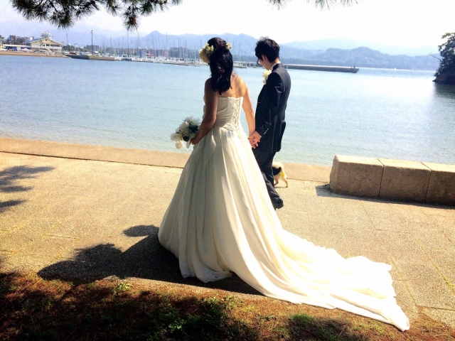 海沿いを歩く新郎新婦