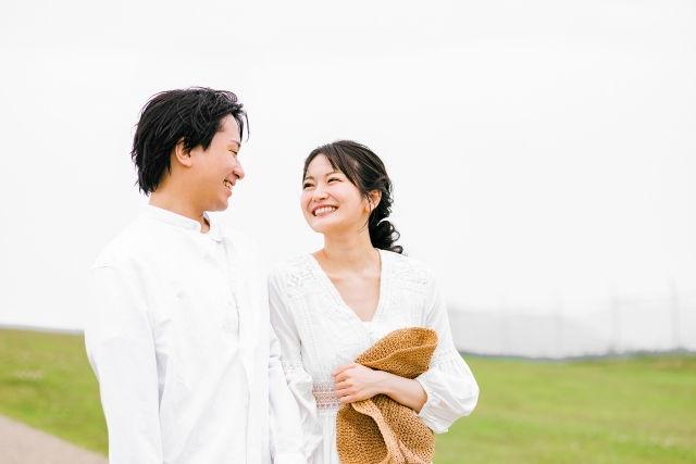 高原を散歩しながら笑顔でお互いの顔を見つめるカップル