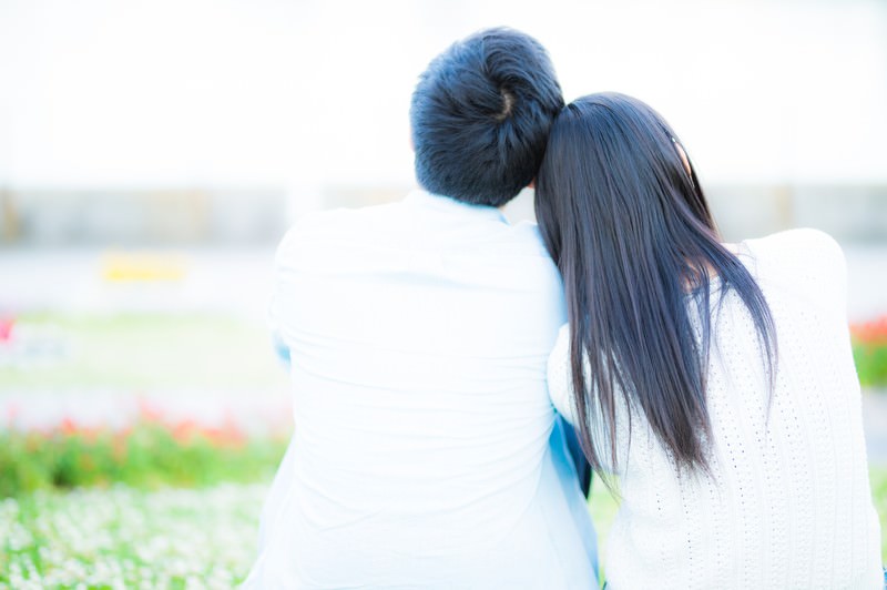 男女が寄りかかり合っている背中の画像