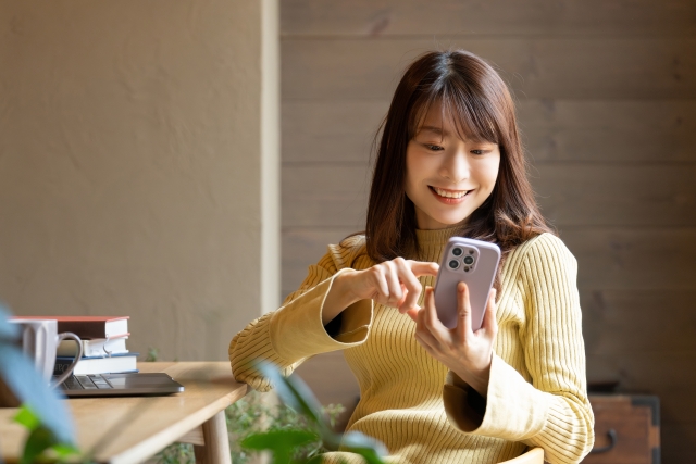 スマホを操作する女性の画像