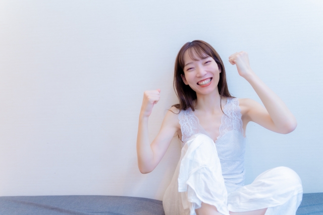 ガッツポーズをする笑顔の女性の画像