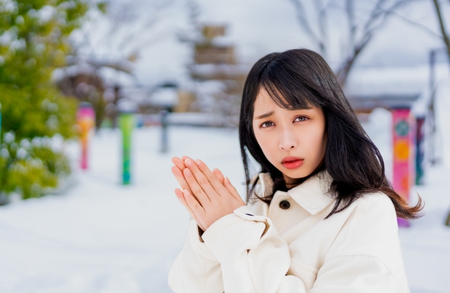 寒そうに困った表情をしている女性の画像