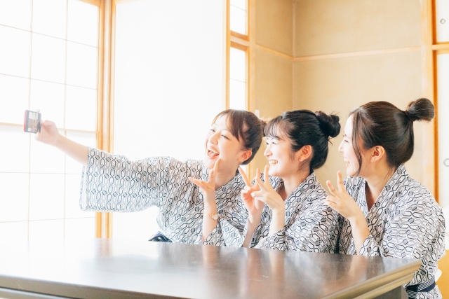 旅行先で自撮りをする女性たちの画像