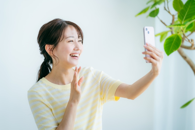 スマホで自撮りをする女性の画像