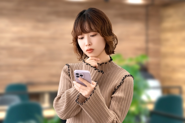 スマホを見る女性の画像