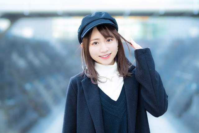 カメラ目線でほほえむ女性の画像