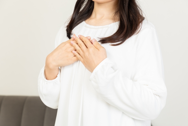 胸に手をあてる女性の画像