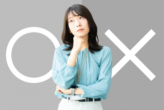 〇か×かで悩んでいる女性の画像
