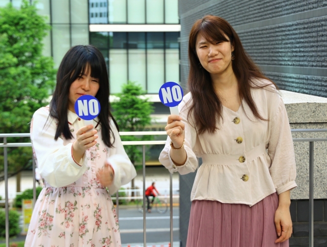 NOの札を出す女性の画像