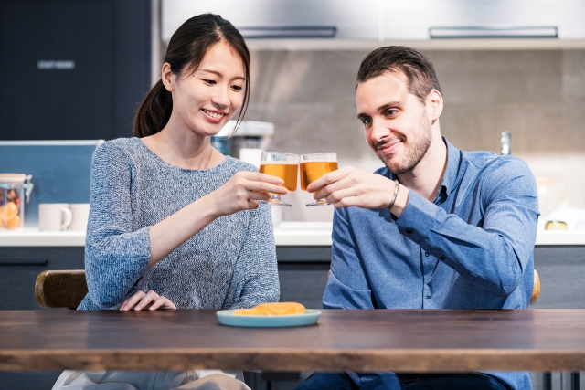 乾杯をする外国人男性と日本人女性のカップル
