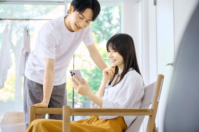 仲良さそうに一緒にスマホを見るカップル