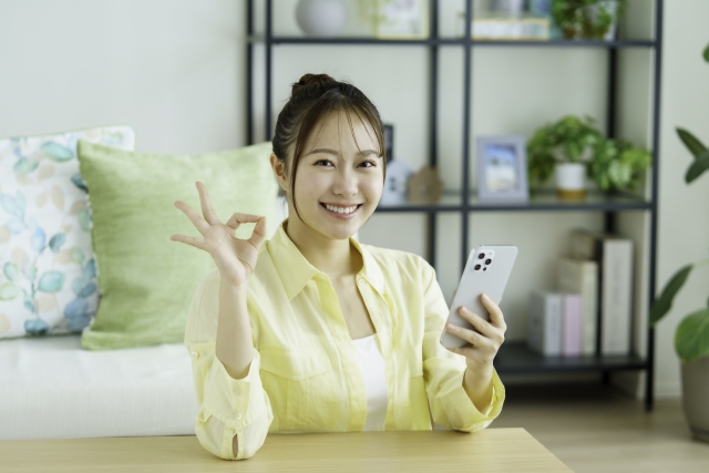 笑顔でオッケーサインをする女性のイメージ画像
