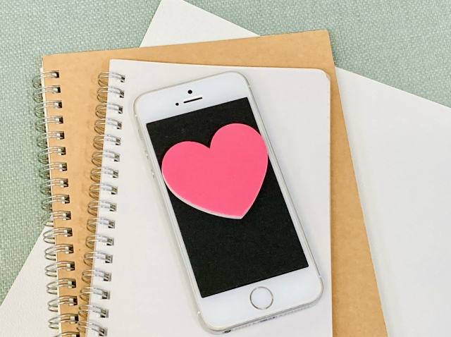 スマホの上にハートのイラストが載ったイメージ画像