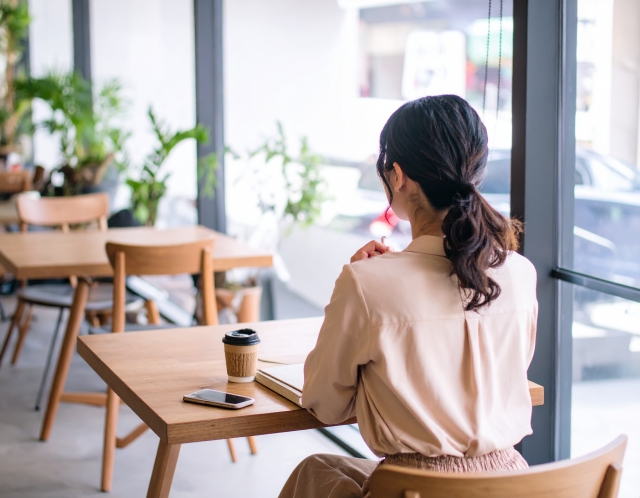 カフェでお茶をする女性の後ろ姿