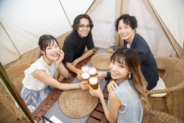 BBQで乾杯をしている4名の男女