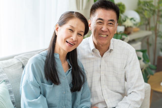ソファに座って笑顔の中高年世代の夫婦