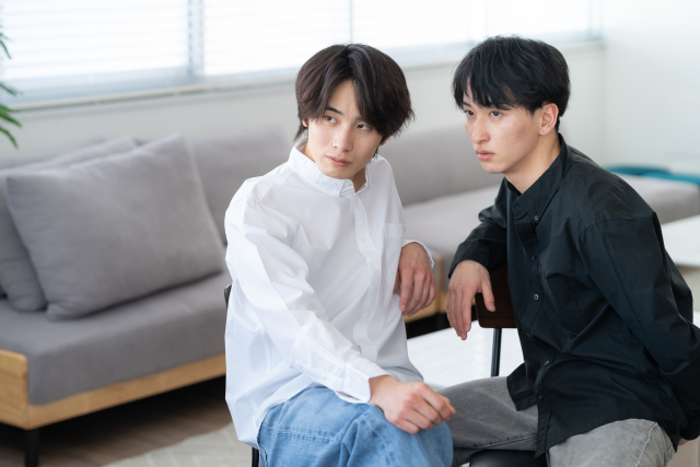ソファでくつろぐ若い男性2名の画像